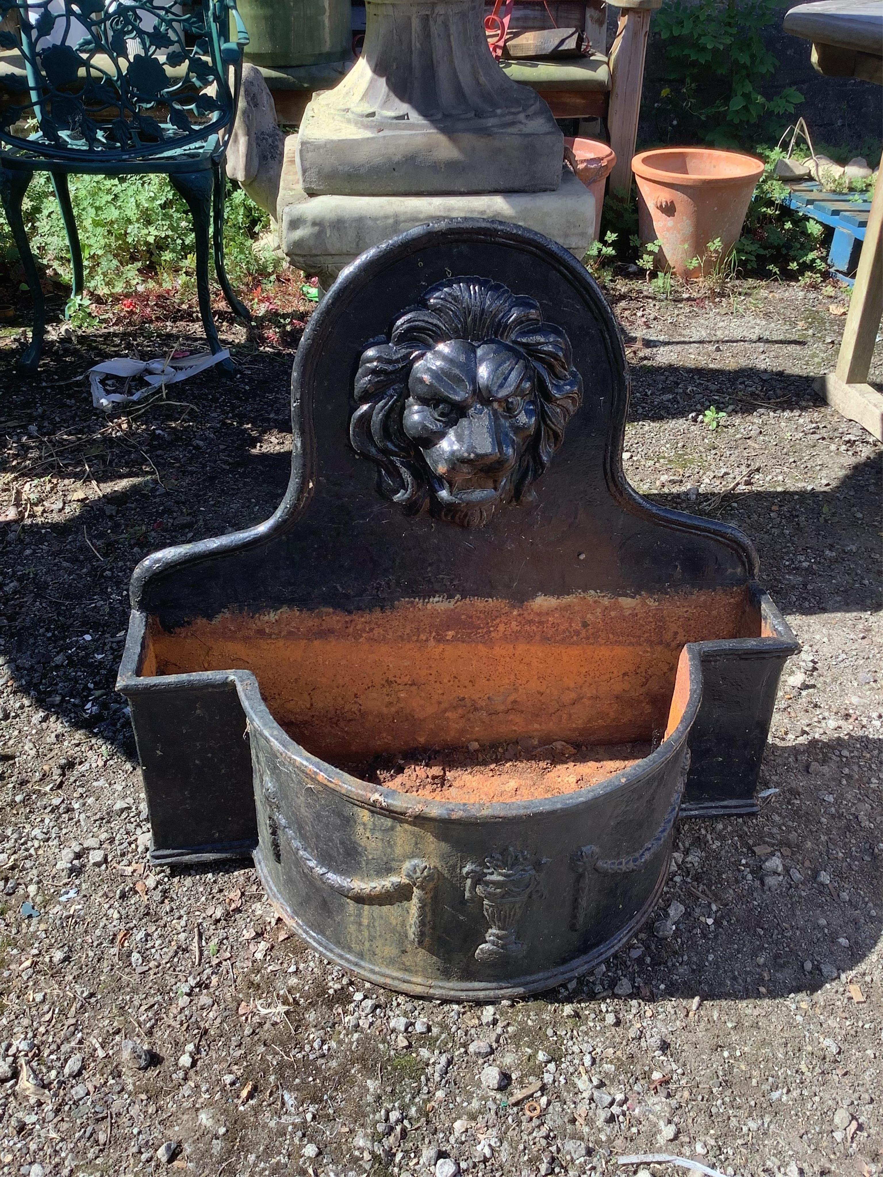 A pair of cast iron lion mask bowfront garden planters, width 69cm, height 65cm. Condition - fair